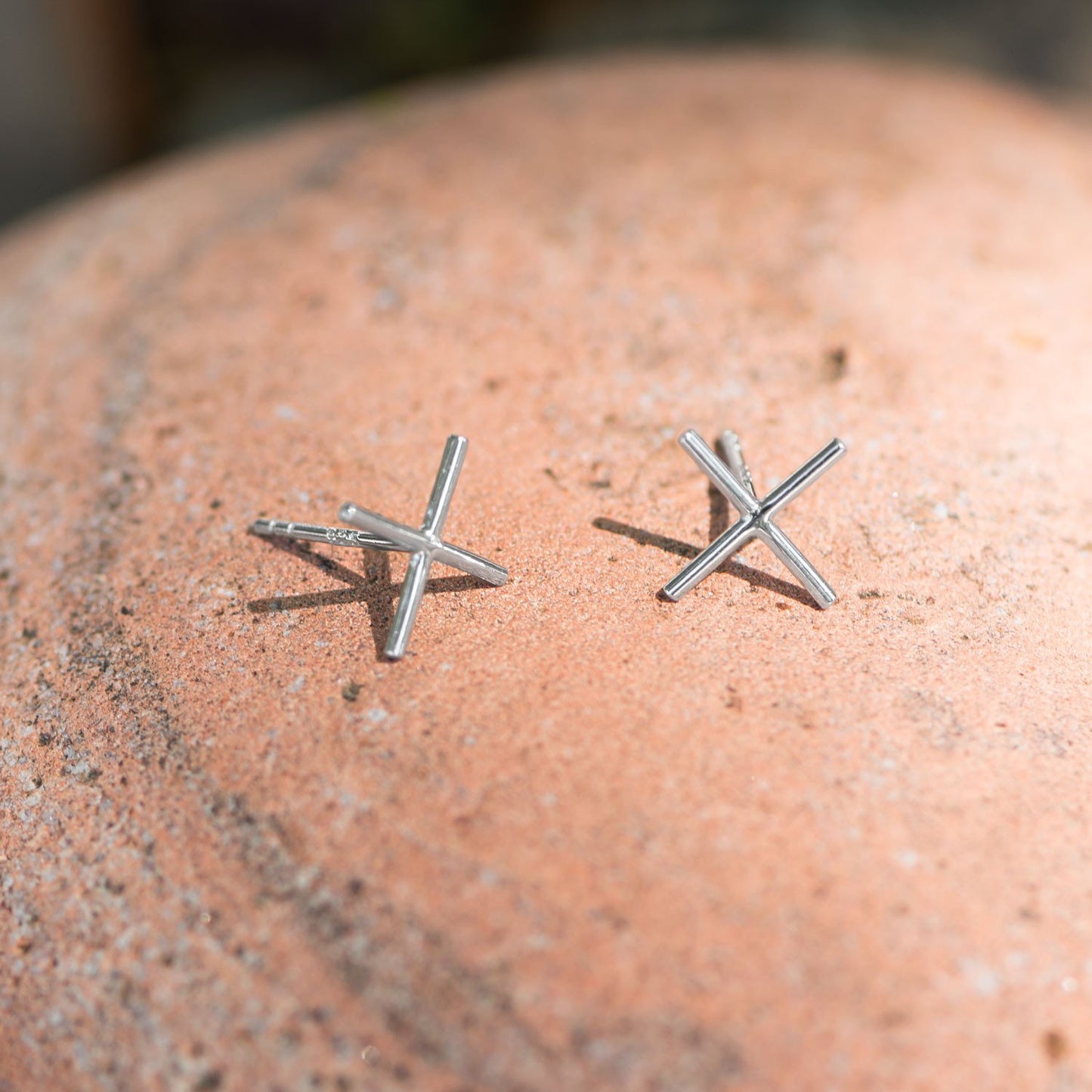 Aretes con forma de "X" chapados en rodio