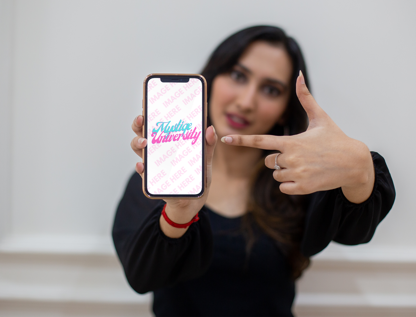 iPhone Mockup With a Woman Pointing to the Middle of the Screen